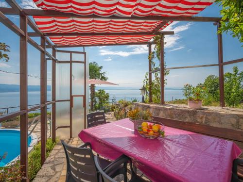 a pink table with a bowl of fruit on it at Holiday Home Villa More by Interhome in Lovran