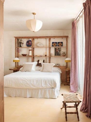 a bedroom with a large white bed and a chair at La Bionda Hotel - Adults Only in Begur