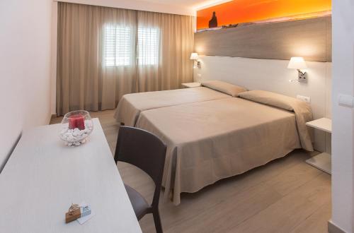 a hotel room with a bed and a table at Typic Art in Es Cana