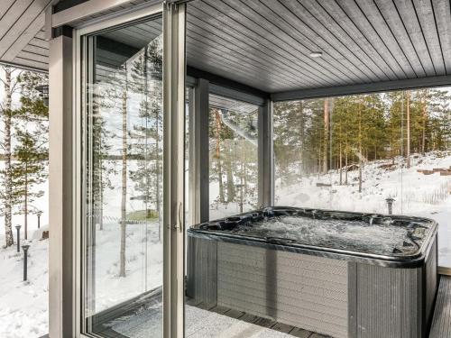 a jacuzzi tub in a room with windows at Holiday Home Villa saunaniemi i by Interhome in Selänpää