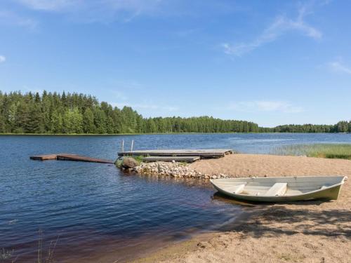 a boat sitting on the shore of a lake at Holiday Home Vuokatticottage f by Interhome in Vuokatti