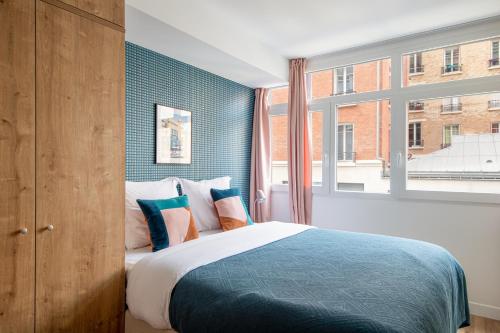 sypialnia z łóżkiem i dużym oknem w obiekcie NEW - Villa Urbaine au Coeur de Paris - 6 pers w Paryżu