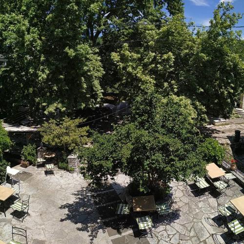 a group of tables and chairs under a tree at En Chora Vezitsa in Vitsa