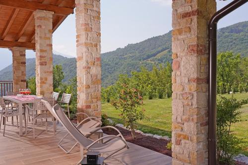 un patio con mesa y sillas en una terraza en Agriturismo Hegemone, en Tremosine Sul Garda