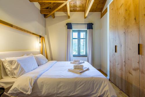 a bedroom with a large white bed with a window at Villa Skyphos in Ammoudari