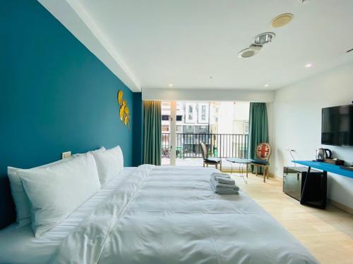 a bedroom with a large bed with a blue wall at Taichung EnrichLife Hotel in Taichung