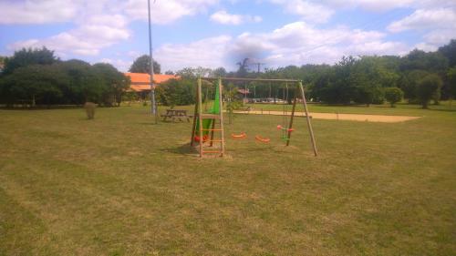 a playground with a swing set in a park at Chambre d'hôtes Au Chant des Vents in Thurageau