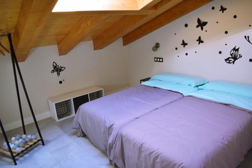um quarto com uma cama com borboletas na parede em ALBERGUE HOSTING DUERO em Pesquera de Duero