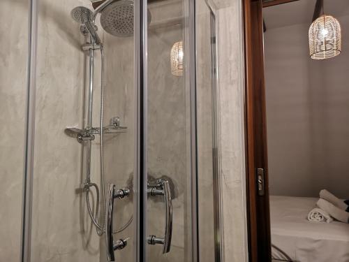 a shower with a glass door in a bathroom at Relax Seaside House by living in blue in Haraki