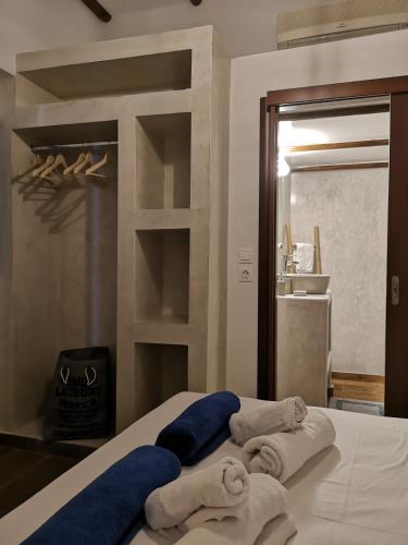 a pile of towels sitting on top of a bed at Relax Seaside House by living in blue in Haraki