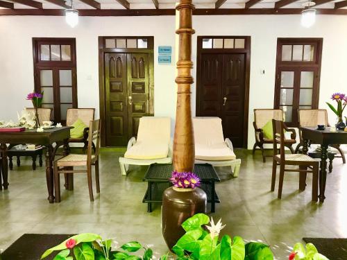 a dining room with tables and chairs and a pole at Walauwa The Villa Ahungalla in Ahungalla