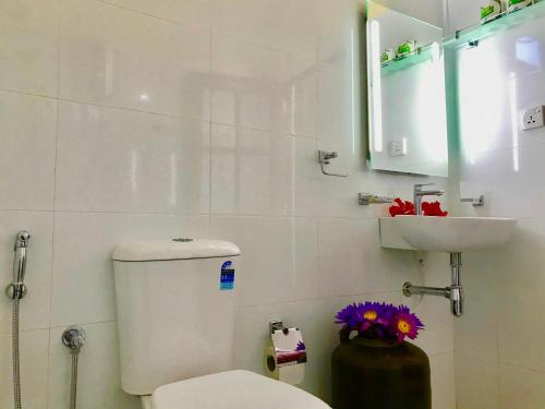 a white bathroom with a toilet and a sink at Walauwa The Villa Ahungalla in Ahungalla