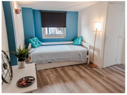 アヴィニョンにあるAventure Avignonnaise - ROOFTOP TERRASSE - INTRAMUROS - CITY CENTERのベッドルーム1室(青い壁、青い枕付きのベッド1台付)
