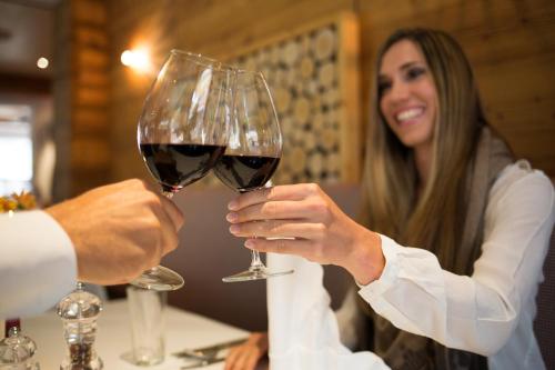 a man and woman holding a glass of wine at Hotel Lohningerhof in Maria Alm am Steinernen Meer