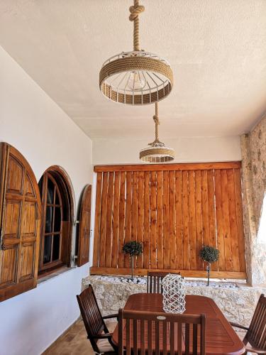 a dining room with a table and chairs and a chandelier at Relax Seaside House by living in blue in Haraki