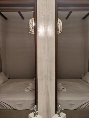 a mirror with two beds in a room at Relax Seaside House by living in blue in Haraki