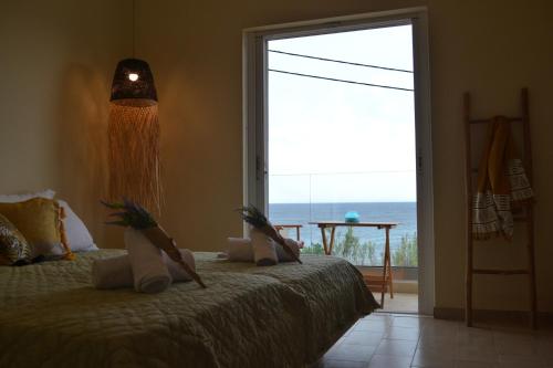 a bedroom with a bed with a view of the ocean at Sole Verde in Agios Georgios