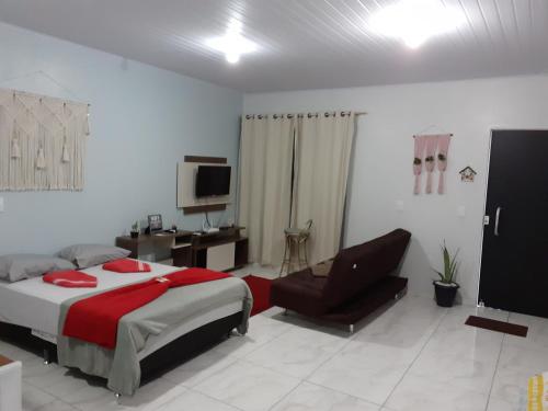 a bedroom with a bed and a chair at loft harmonia in Blumenau
