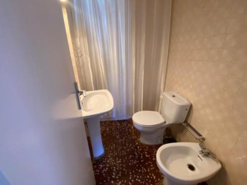 a bathroom with a white toilet and a sink at Mediterranean apartment in Lloret de Mar next to the Sea in Lloret de Mar