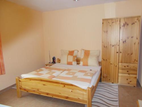 a bedroom with a bed and a wooden cabinet at Gästehaus am Reiterhof Mutschler in Donzdorf