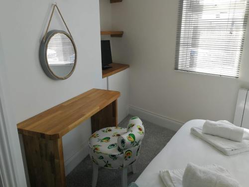 um quarto com um espelho, uma mesa e uma cadeira em Derby Den by Cliftonvalley Apartments em Bristol