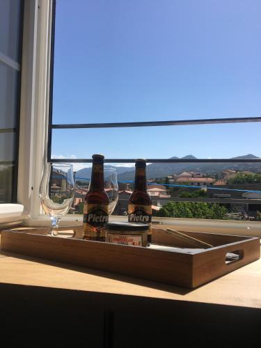 - deux bouteilles de bière et des verres sur un plateau à la fenêtre dans l'établissement CasaRadriimas, un cocon au cœur du Centre Ville, à Propriano