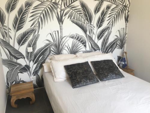 une chambre avec un lit avec un papier peint tropical dans l'établissement CasaRadriimas, un cocon au cœur du Centre Ville, à Propriano