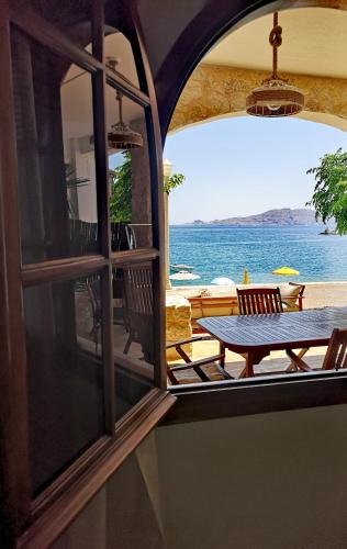 a view of the ocean from a room with a table at Relax Seaside House by living in blue in Haraki