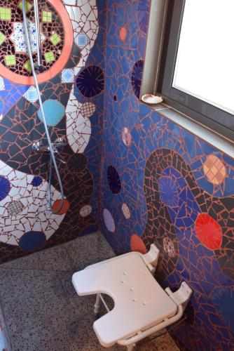 a toilet in a bathroom with a colorful wall at Casa Boa Onda in Lajes das Flores