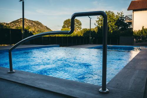 a swimming pool with a metal rail around it at Adria centar Koćuša in Ljubuški