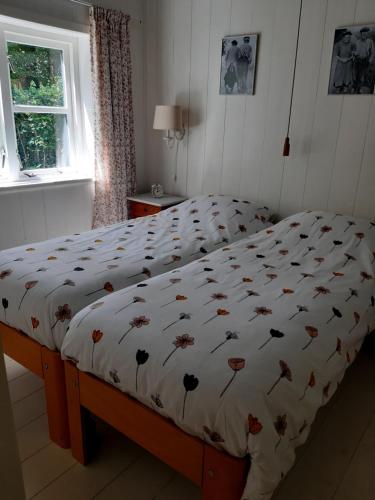 een bed met een dekbed in een slaapkamer bij B&B Appartement De Winkeljuffer in Bakkeveen