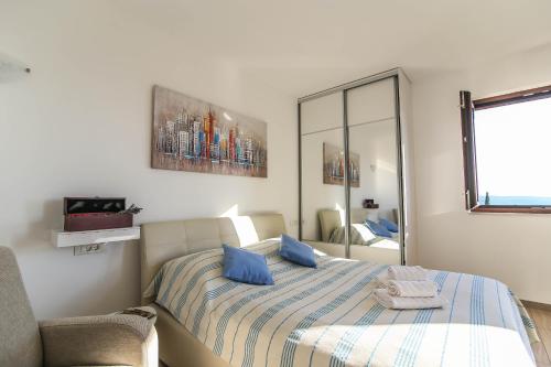 Un dormitorio con una cama con almohadas azules y una silla en Rural Accommodation Veselic, en Pridvorje