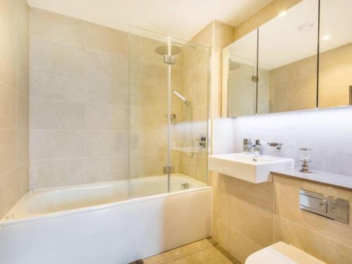 a bathroom with a tub and a toilet and a sink at Luxurious serviced apartment in Croydon in Croydon