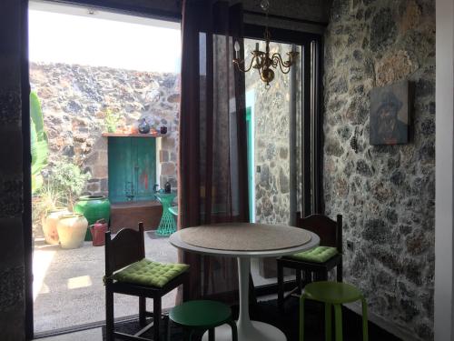 mesa y sillas en una habitación con ventana en El Patio del Charco– Eine Oase mitten in der Stadt, en Arrecife