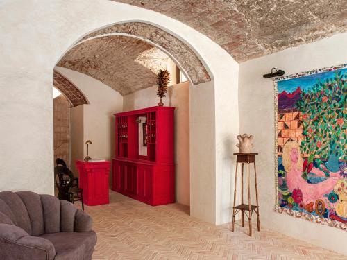 a living room with a red cabinet and a painting at La Bionda Hotel - Adults Only in Begur