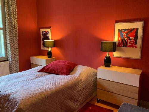 BodenfeldeにあるSchlössliches Ambiente mitten in der Naturの赤い壁のベッドルーム1室、ベッド1台、ランプ2つ