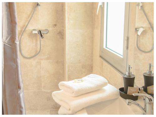 La salle de bains est pourvue d'une douche et de 2 serviettes blanches. dans l'établissement Aventure Avignonnaise - AUTHENTIQUE - INTRAMUROS - CITY CENTER, à Avignon