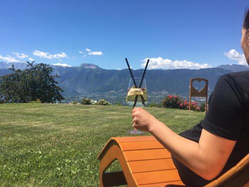 une femme assise sur un banc avec une maison d'oiseaux dans l'établissement Hotel Antica Torre, à Coredo