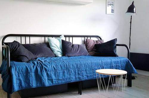 MirskにあるApartament Mirskのベッド1台(青い毛布、テーブル付)