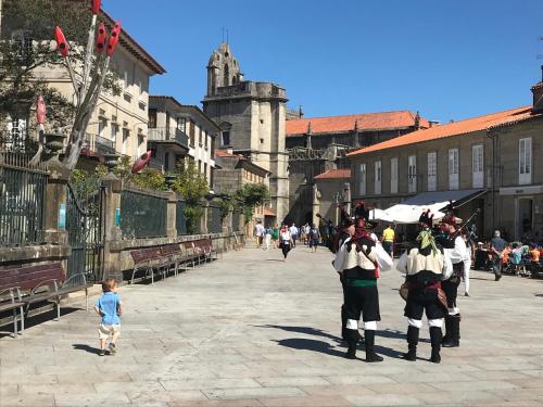a group of people dressed in medieval clothing walking down a street at APT Slow City Hostel in Pontevedra
