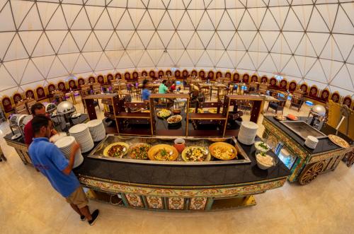 
a restaurant filled with tables full of food at Memories Aicha Luxury Camp in Wadi Rum
