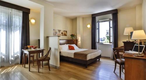 Habitación de hotel con cama, mesa y escritorio. en Hotel & Residence Torino Centro - Stazione Porta Susa, en Turín