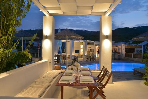 a patio with a table and chairs and a pool at Elsa Hotel in Skiathos Town