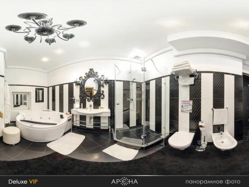 a bathroom with a tub and a toilet and a sink at Arena in Khmelnytskyi