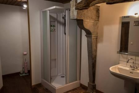 a bathroom with a glass shower and a sink at Gîte de Lolotte et Gégé in Audeux