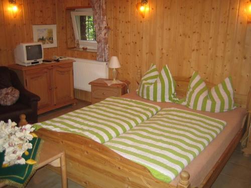 Cama grande en habitación con paredes de madera en Pension Elbblick Sabine Zuschke, en Meißen