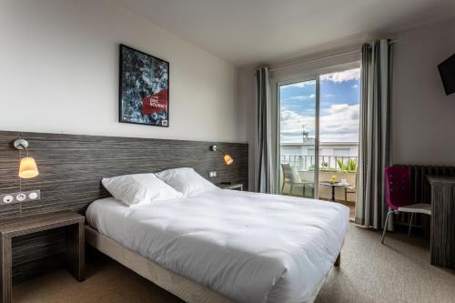 A bed or beds in a room at Hôtel du Midi Plage