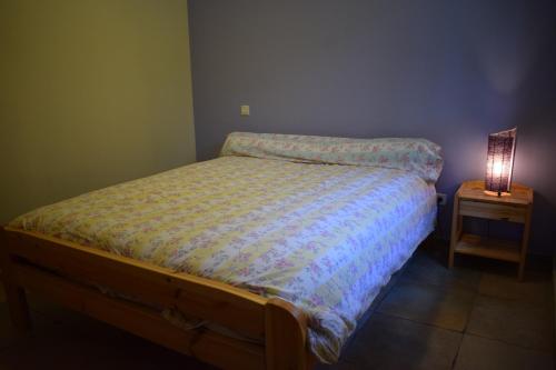 ein Bett in einem Schlafzimmer mit einer Lampe auf einem Nachttisch in der Unterkunft Le Gîte des écureuils in Lunel-Viel