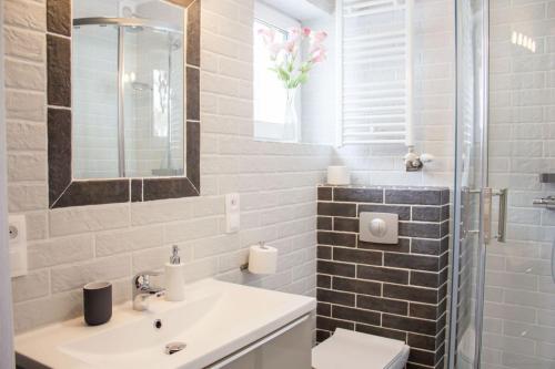 ein Badezimmer mit einem Waschbecken, einem WC und einem Spiegel in der Unterkunft Apartamenty JustRent Szczyrk in Szczyrk