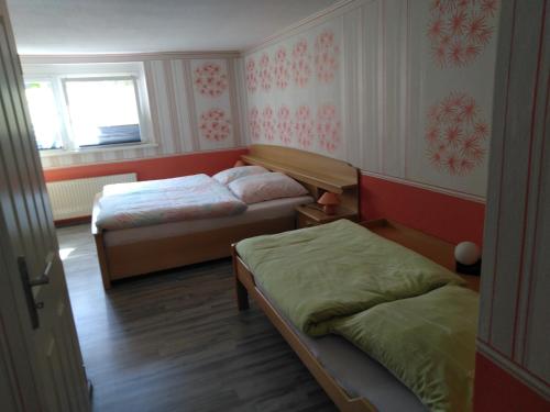 a small room with two beds and a window at Urlaub im Fachwerkhaus in Gernrode - Harz